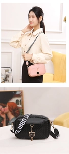 Close-up of woven crossbody camera bag with cat charm and 1980 NEW wide shoulder strap