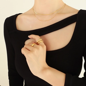 Minimalist double layer gold plated snake chain necklace and textured rings on model