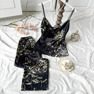 Elegante completo in raso nero con canotta e pantaloni a stampa floreale da donna
