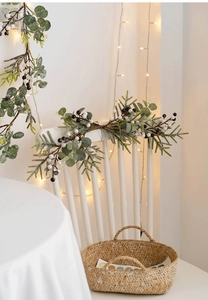 Detail of Christmas wreath with eucalyptus and white berries on a white wooden chair