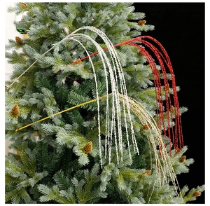 Detail of glittering Christmas tree picks in red and gold finish for festive DIY decoration