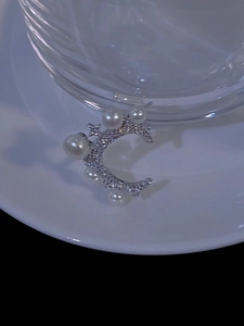 Detailed view of silver star and moon ring with zircon stones and white pearls