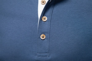 Macro detail of navy blue Henley shirt collar with three amber resin buttons and fine knit