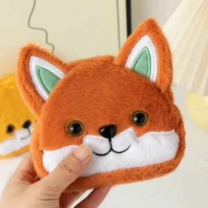 Close-up of cute plush fox coin purse with orange fur, green ears and embroidery details