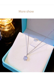 Macro shot of silver six-prong cubic zirconia pendant necklace in a luxury blue gift box