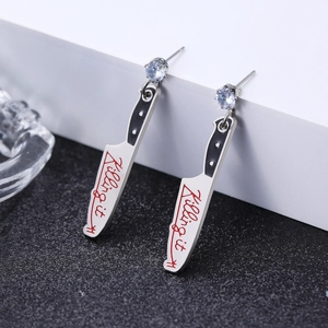 Detailed shot of creative silver punk earrings in kitchen knife shape with Killing It text