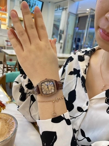 Detail of square vintage watch with rhinestone bezel and brown leather strap on wrist