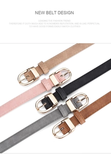 Detail view of five assorted slim belts with golden oval buckles on a white background