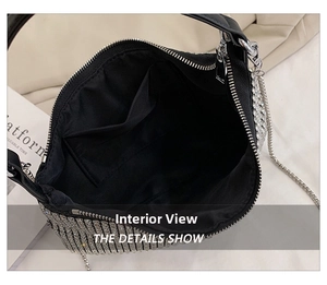 Detail view of the black fabric lining, inner pocket and silver zipper of the rhinestone bag