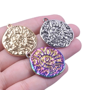 Macro shot of colorful stainless steel sun charms in gold, silver, and rainbow finishes