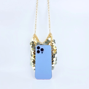 Detail of golden sequin mini bag with metal chain strap and phone for size reference