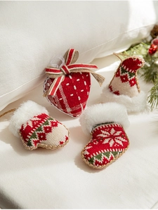 Detail of red and white knitted Christmas ornaments set with bows and faux fur trim