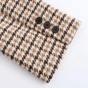 Classic houndstooth plaid coat sleeve detail with three black decorative buttons