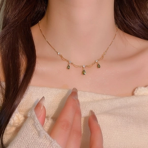 Dettaglio della collana placcata oro con pietre a goccia verdi e inserti in zirconia