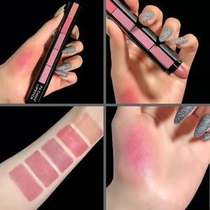 Fünffarbiger matter Lippenstift-Stack mit Farbmustern auf Arm und Hand auf Schwarz