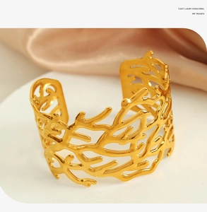 Detailed view of hollow out gold cuff bracelet with nature inspired branch texture