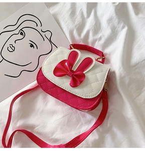 Detail view of pink and white bow handbag with classic quilted pattern and golden hardware