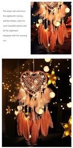 Close-up of pink heart dream catcher with soft feathers, wood beads and LED string lights