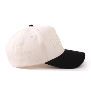 Dettaglio cappellino in cotone beige con visiera nera e ricamo laterale elegante