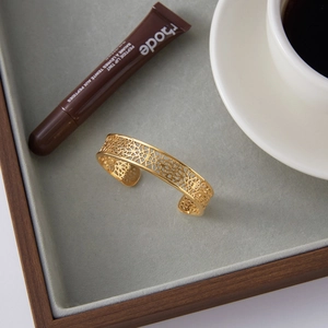 Exquisite gold-plated titanium steel hollow bangle displayed in a premium velvet tray