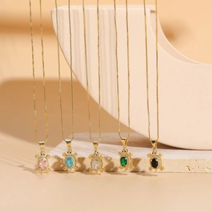 Détail de pendentifs tortue en cinq couleurs sur colliers plaqués or 14K