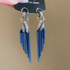 Close-up of elegant long blue tassel earrings with sparkling rhinestones and silver chains