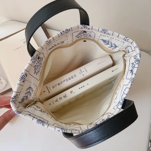 Top view of canvas tote bag interior with floral lining and leather handles