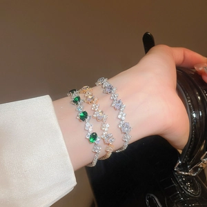 Detailed view of three zirconia bracelets in emerald green, rose gold, and silver finishes