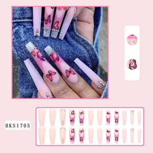 Detailansicht langer Sargnägel mit rosa Schmetterlingsmustern und funkelnden Strasssteinen