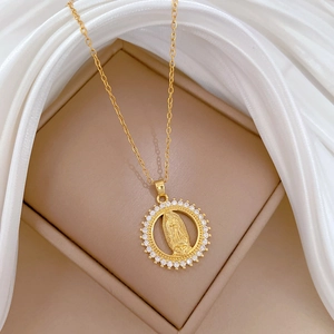 Close-up of gold Virgin Mary pendant with sparkling crystals on white silk
