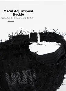 Close-up of black baseball cap with distressed fringe fabric and silver metal buckle
