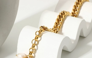 Detailed macro of 18K gold plated Cuban chain bracelet with freshwater pearl drop