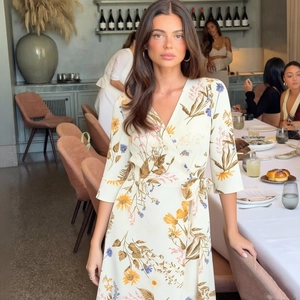 Elegant V-neck floral wrap dress with side ties and midi sleeves in a luxury restaurant