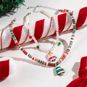 Flat lay of Santa and Christmas tree necklaces with pearls and colorful clay beads