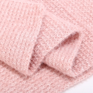 Macro detail of soft pink chunky knit winter set showing thick wool texture and yarn