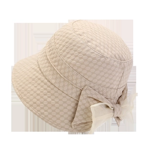 Macro detail of beige bucket hat featuring waffle texture and elegant organza bow
