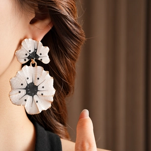 Détail d'un mannequin portant des boucles d'oreilles vintage fleurs de ginkgo dorées