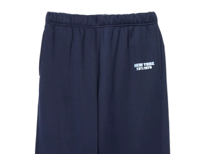 Flat lay of navy blue sweatpants with elastic waist and New York EST.1975 print detail