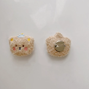Detail of plush bear brooch showing soft lamb wool texture and metal safety pin back