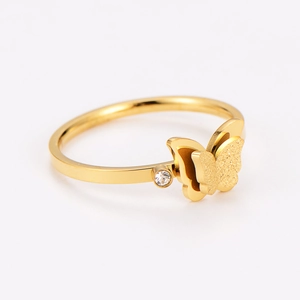 Detail of gold butterfly ring featuring matte wings and a white sparkling zircon stone