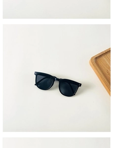 Detail of foldable kids sunglasses with black frames and dark UV protection lenses
