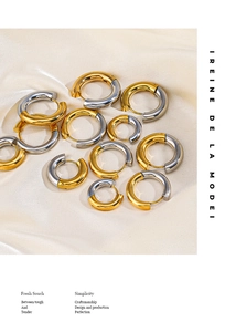 Detail of mixed gold and silver hoop earrings in multiple sizes on silk background