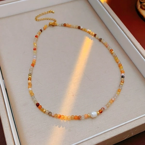 Close-up of titanium steel necklace featuring colorful beads and a freshwater pearl