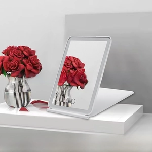 Close-up of white LED travel makeup mirror with foldable stand and touch control