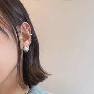 Silver heart stud earring and minimalist cuff set shown on a model's ear