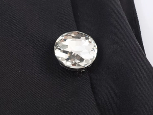 Dettaglio ravvicinato di un bottone di cristallo rotondo su un pregiato tessuto twill nero