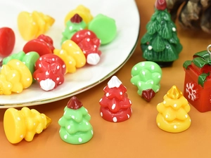 Close-up of colorful resin Christmas tree and gift box charms for DIY craft projects