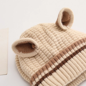 Detail of warm waffle knit baby hat with bear ears and brown striped elastic brim