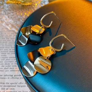 Detail von geometrischen Ohrhängern mit gold silber und schwarz Metall-Pailletten