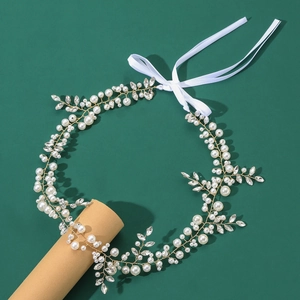 Détail de bandeau de mariée avec fils d'or, perles blanches et strass étincelants